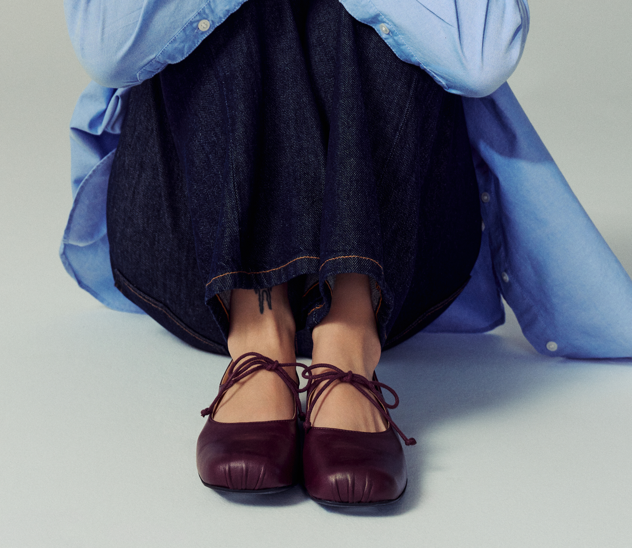 Woman sitting down and wearing black heeled ankle boot