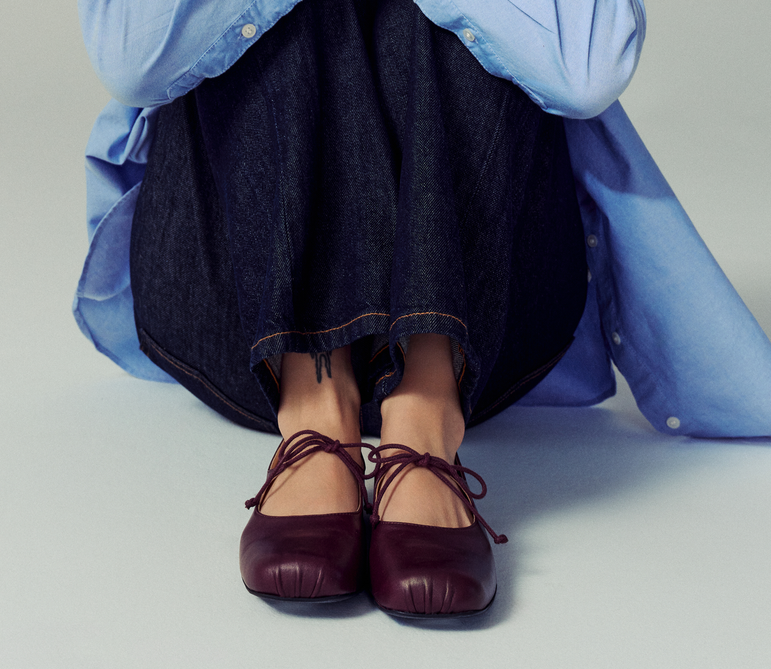 Woman sitting down and wearing black heeled ankle boot