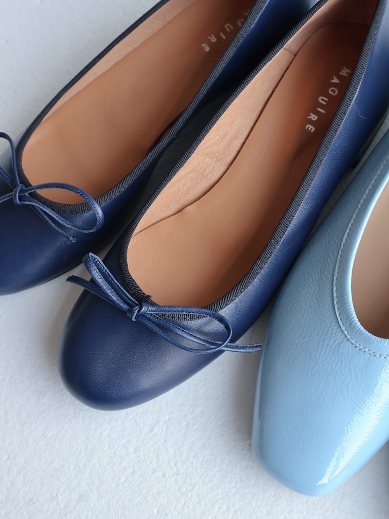 Pair of blue shoes with a bow on a white background