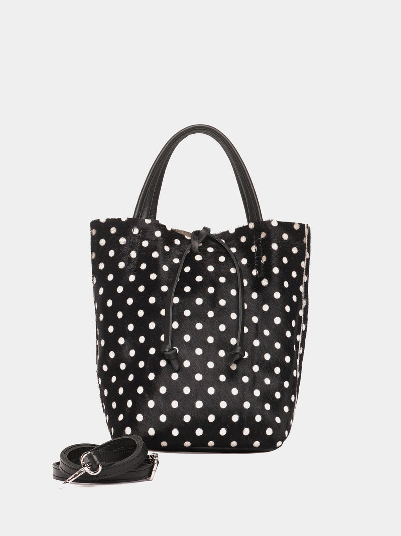 Black tote bag with white polka dots with a black crossbody strap