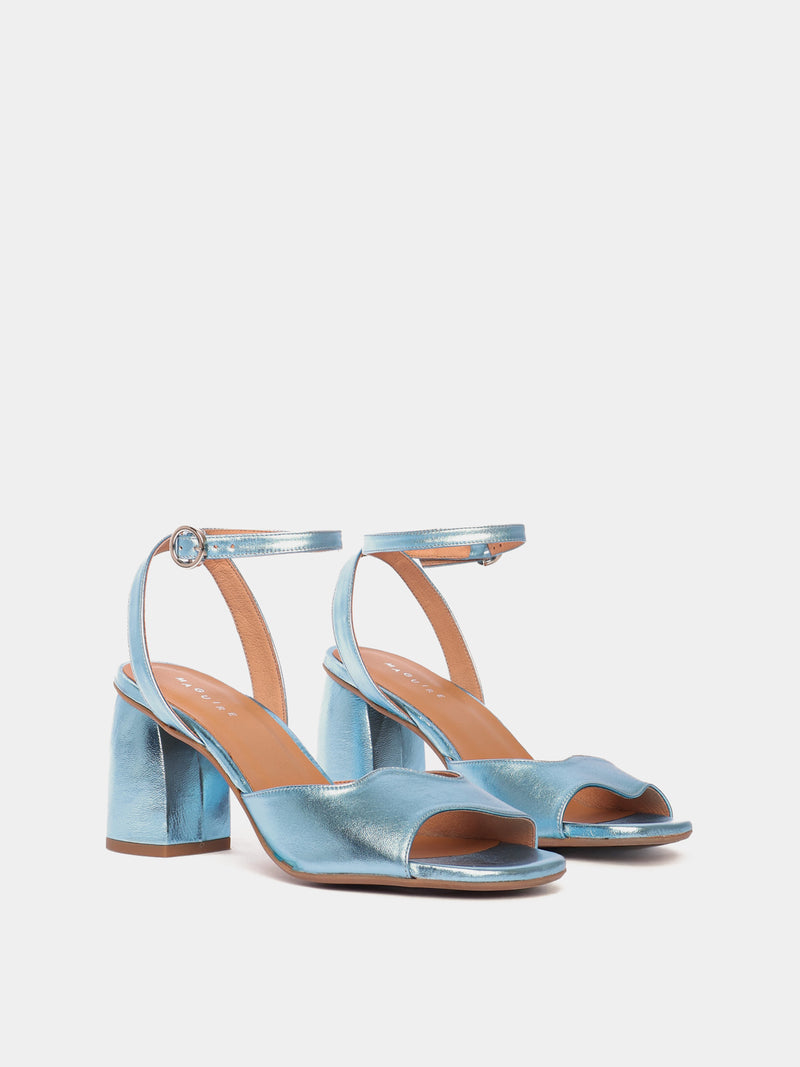 Blue metallic heels with an asymmetric wave design and adjustable ankle straps.