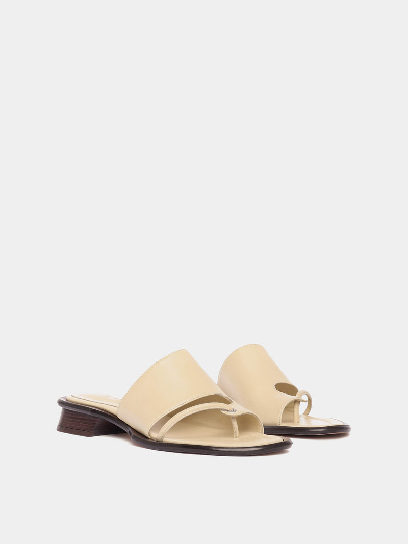 Beige leather sandals with sculptural wooden heels and a soft upper.