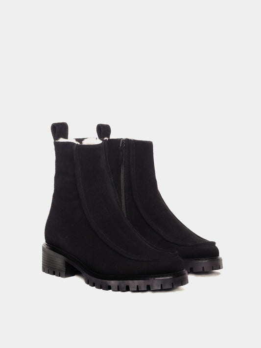 Shearling lined winter boot with a front piping detail, in a black suede with a black lug outsole. 