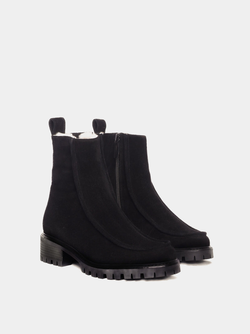 Shearling lined winter boot with a front piping detail, in a black suede with a black lug outsole. 