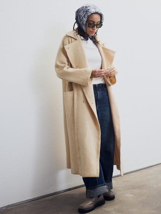 Long beige coat with denim pants and taupe Chelsea boots