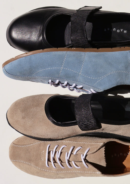 Four pairs of shoes in black, blue, beige, and brown on a white background
