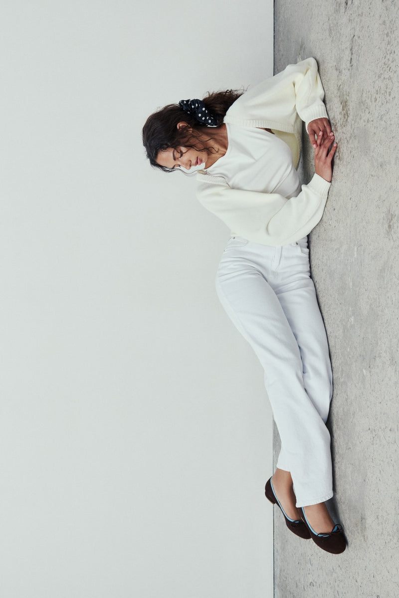 Woman wearing a white outfit against a plain background with Brown Covelo Ballet flats.