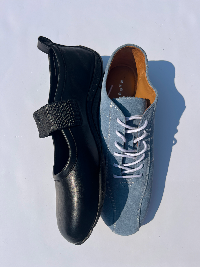 Black shoe with a strap and blue suede shoe on a white background